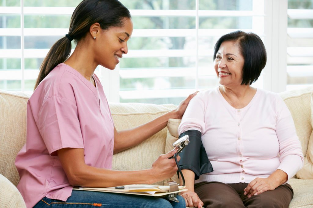 Home care nurse checking a client's blood pressure